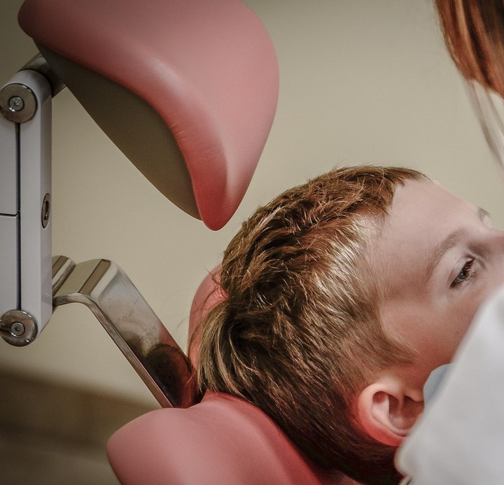 dentist examining patient in chair